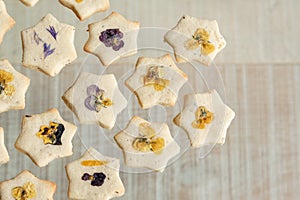 Star shaped biscuits decorated with edible flowers, pansies and cornflower petals.