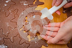 Star-shaped cake is lifted by a womanâ€™s hands with a white spatula, the preparation for Christmas pastries
