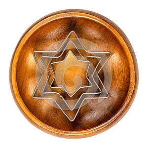 Star shaped cookie cutters, hexagram shaped biscuit cutters, in a wooden bowl photo