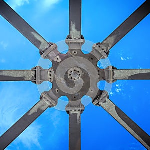 Star-shaped supporting structure taken from below against the blue sky, abstract geometric impression