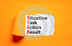 STAR situation task action result symbol. Concept words STAR situation task action result on white paper on beautiful orange