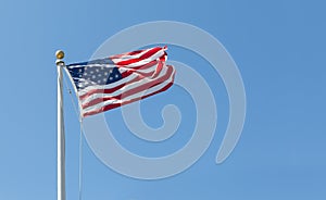 American flag on the blue sky background, turned to the right