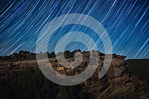 Star trail above rock cliff photo