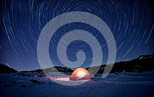Star Trails On Illuminated Tent In The Snow