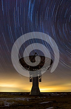 Star trails over radio telescope