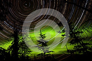 Star trails and Northern lights in sky over taiga