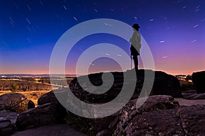 Star trails over boulders and statue on Little Round Top at nigh