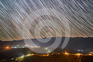 Star trails over the Pestera village in Piatra Craiului mountains from Romania