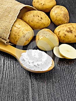 Starch potato in spoon on wooden table