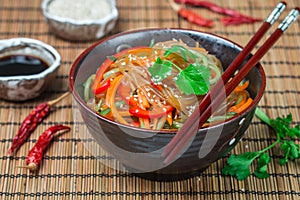 Starch rice, potato noodles with vegetables - bell peppers, carrots, cucumber, sesame seeds, cilantro and soy sauce