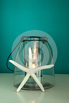 Starfish against a candle with an aqua blue green background