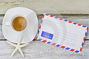 Starfish on Espresso coffee next to blank classic air mail envelope