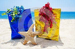 Starfish with gift bags on the beach - holiday concept