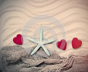 Starfish, hearts and fishnet on the sand