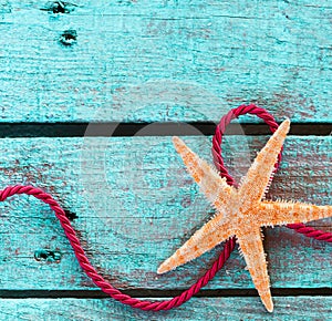 Starfish with looped rope on turquoise wood