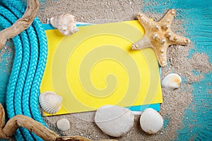 Starfish, pebbles and shells lying on a blue wooden background with postcard. There is a place for labels.