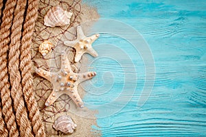 Starfish, pebbles and shells lying on a blue wooden background . There is a place for labels.