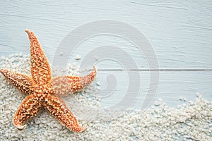 Starfish and sand on blue wooden background. Copy space for the text.