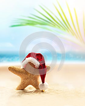 Starfish in Santa hat on the summer beach. Christmas concept