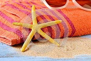 Starfish, sunglasses and beach towel