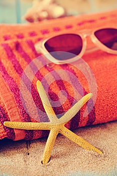 Starfish, sunglasses and beach towel