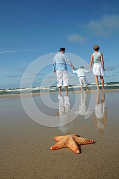 Starfish and tranquil family on the beach