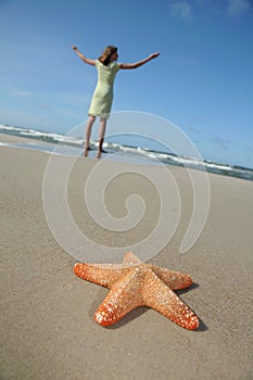 Starfish and tranquil girl on the beach