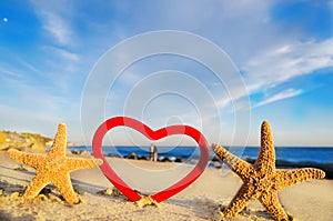 Starfishes with heart on the sandy beach