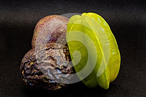 Starfruit and two maracujas  - Stilllife of  tropical fruits against a dark background