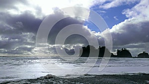 Stark contrast of sea stacks near the beach with blue sky