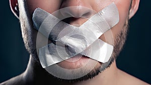The mouth, taped shut, symbolizes the suppression of free speech. This stark representation highlights the struggle for self- photo