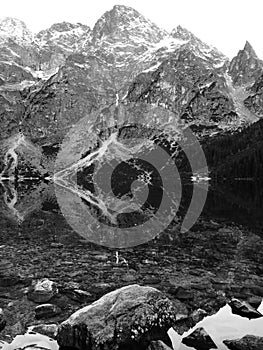 A stark reflection of the waters and stones of Morskie Oko - Poland - Tatra National Park in the Rybi Potok Valley photo