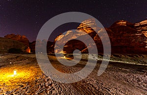 Starlight sky over illuminated desert, night panorama, Hegra, Al Ula, Saudi Arabia