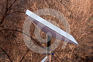 Starlink satellite dish, an internet constellation operated by SpaceX, is installed on the wall of an apartment building. View