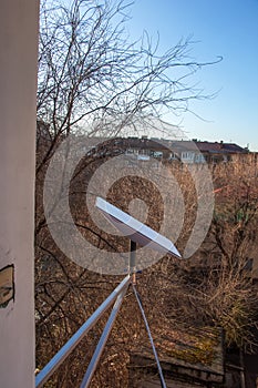 Starlink satellite dish, an internet constellation operated by SpaceX, is installed on the wall of an apartment building. View