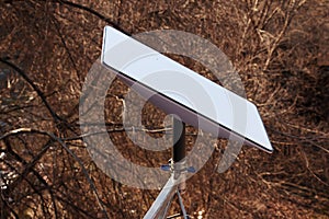 Starlink satellite dish, an internet constellation operated by SpaceX, is installed on the wall of an apartment building. View