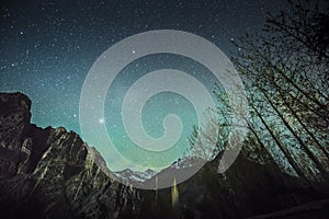 Starry green sky above high mountains on winter night Leh Ladakh India