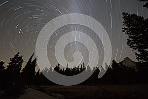 Starry night sky with circular star trails and blurred Milky Way