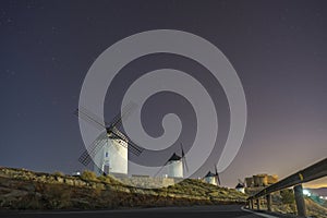 Starry night sky under the windmills of the medieval town of Consuegra.