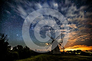 Starry sky above an old wooden windmill