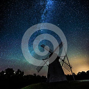 Starry sky above an old wooden windmill