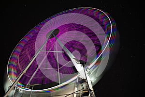 Starry sky behind ferris wheel. Long exposure