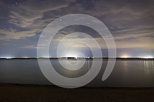 Starry sky on the lake. Night landscape. Sky with clouds. Kyrgyzstan, Lake Issyk-Kul