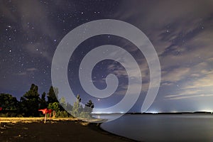 Starry sky on the lake. Night landscape. Sky with clouds. Kyrgyzstan, Lake Issyk-Kul