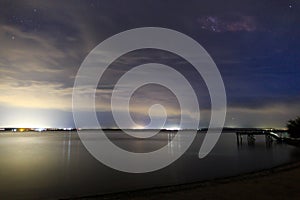 Starry sky on the lake. Night landscape. Sky with clouds. Kyrgyzstan, Lake Issyk-Kul