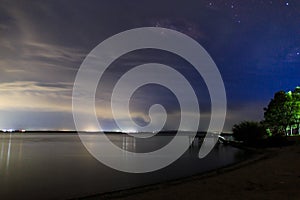 Starry sky on the lake. Night landscape. Sky with clouds. Kyrgyzstan, Lake Issyk-Kul