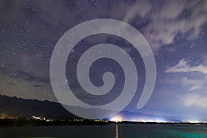 Starry sky on the lake. Night landscape. Sky with clouds. Kyrgyzstan, Lake Issyk-Kul