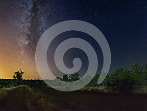 Starry sky with Milky Way galaxy over the summer night rural landscape