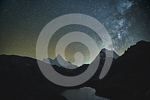 Starry sky over mountain and lake in yading national park, china