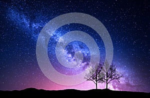 Starry sky with pink Milky Way and trees. Night landscape